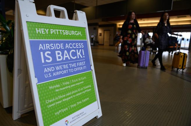 Los viajeros pasan un letrero con información sobre pases de acceso para no viajeros en el Aeropuerto Internacional de Pittsburgh (PIT) en Moon Township, Pennsylvania, EE. UU., (Justin Merriman / Bloomberg)